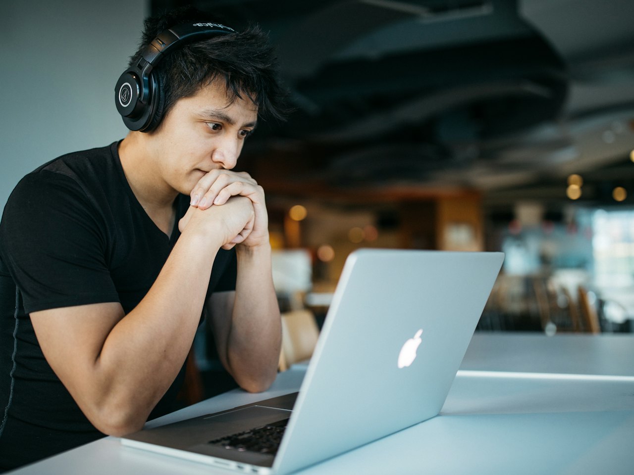 Learner with headphones practising on a laptop