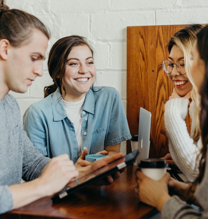 Friends chatting and laughing over coffee at a table