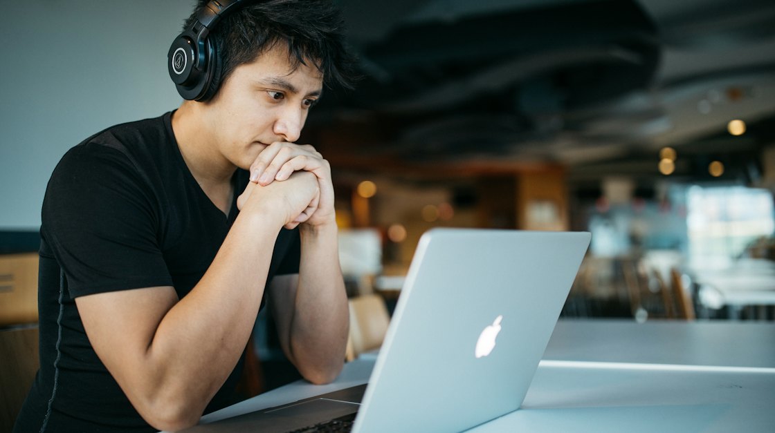 Learner with headphones practising on a laptop