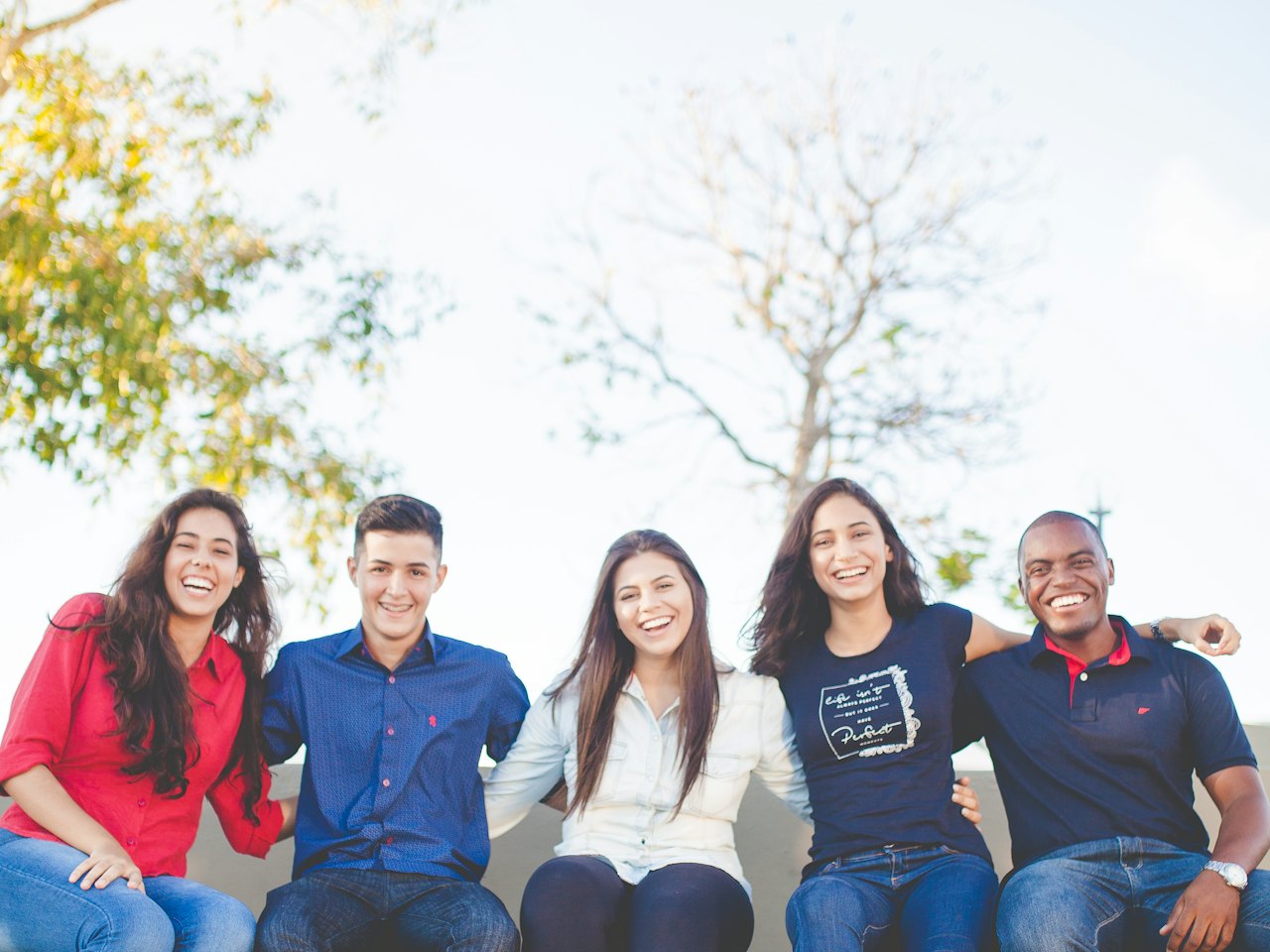 Group of smiling friends sitting together outdoors
