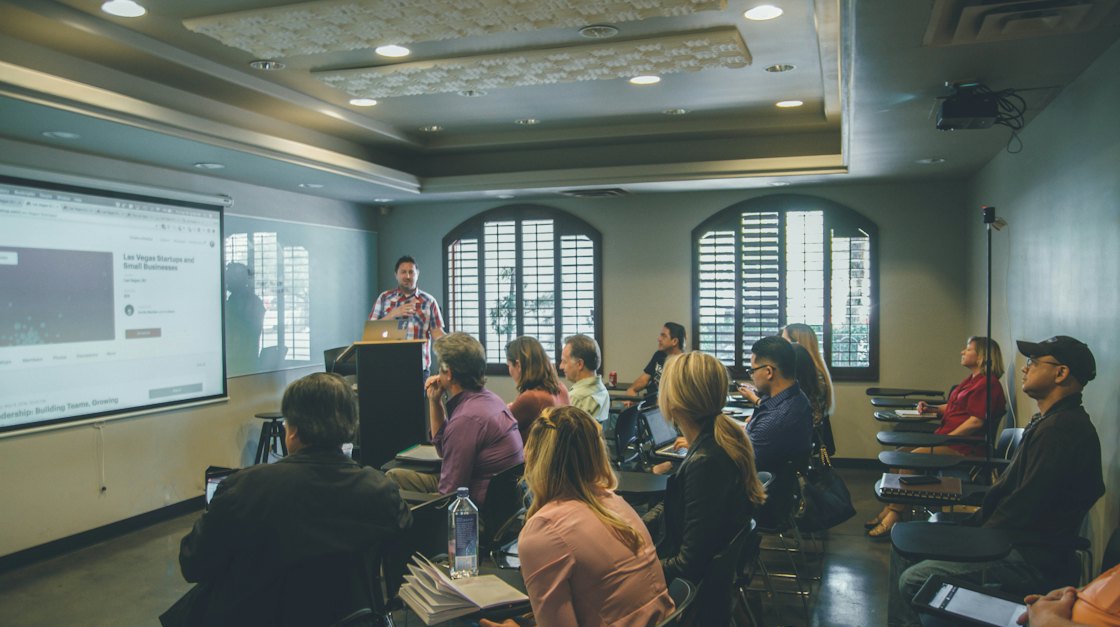 Adult learners in a bright classroom following a presentation