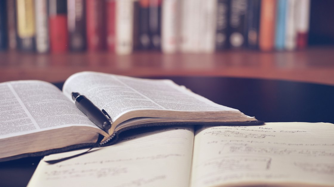 Open books and notes on a library table