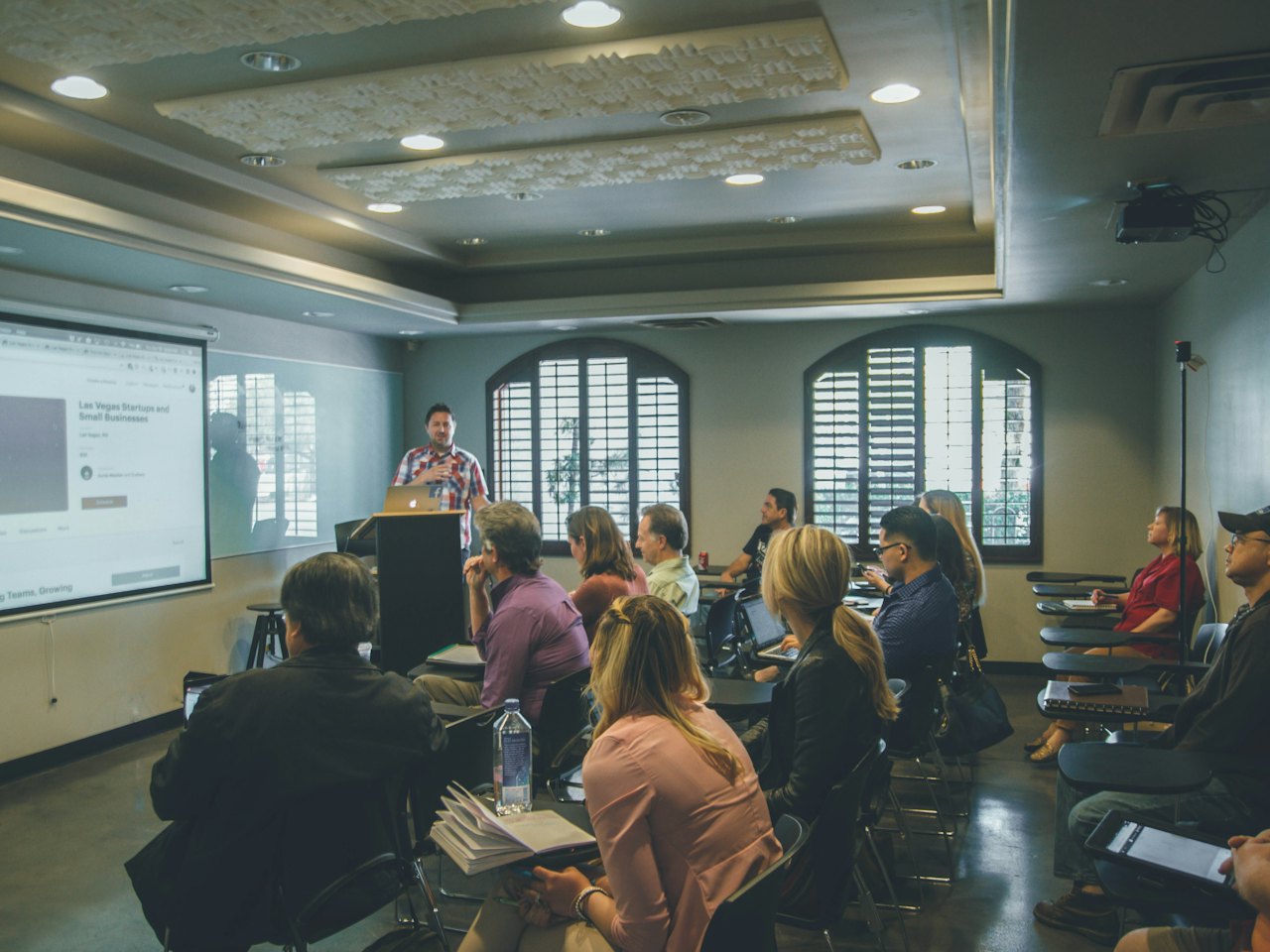 Adult learners in a bright classroom following a presentation