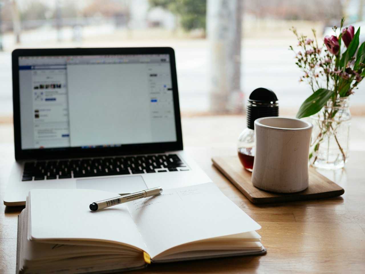 Laptop, notebook and coffee on a wooden table